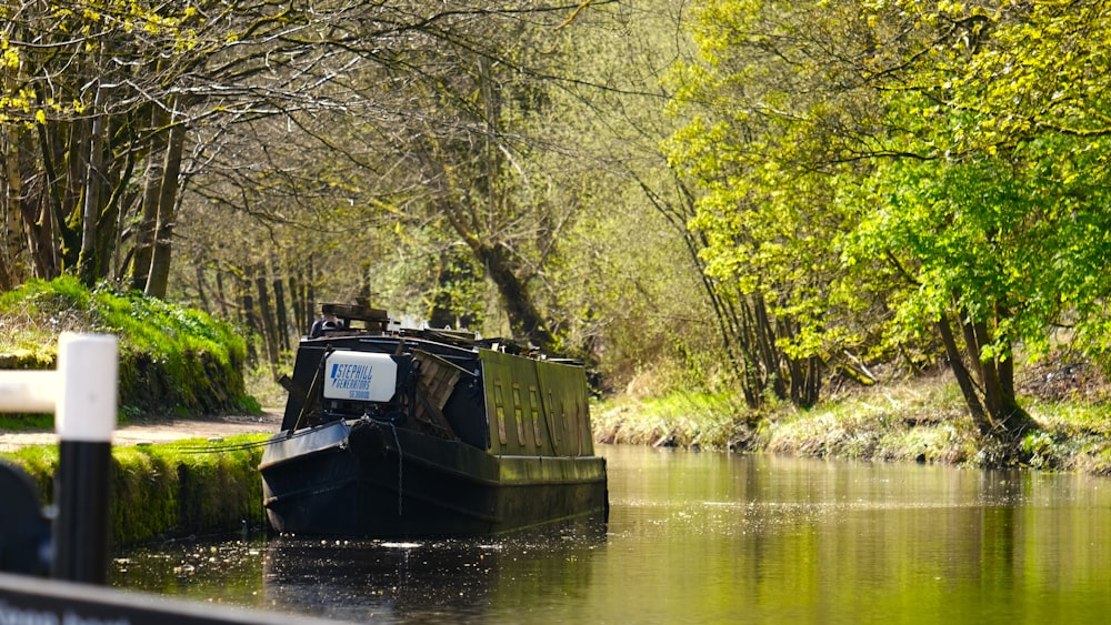 a small boat traveling down a river next to a forest