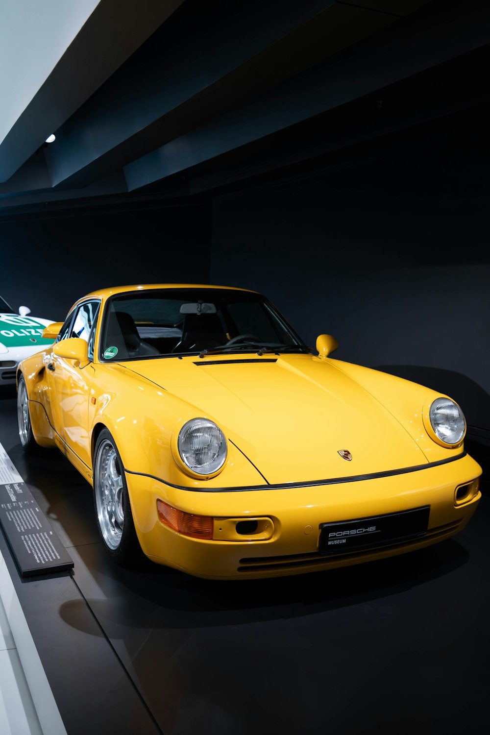 a yellow sports car is on display in a museum