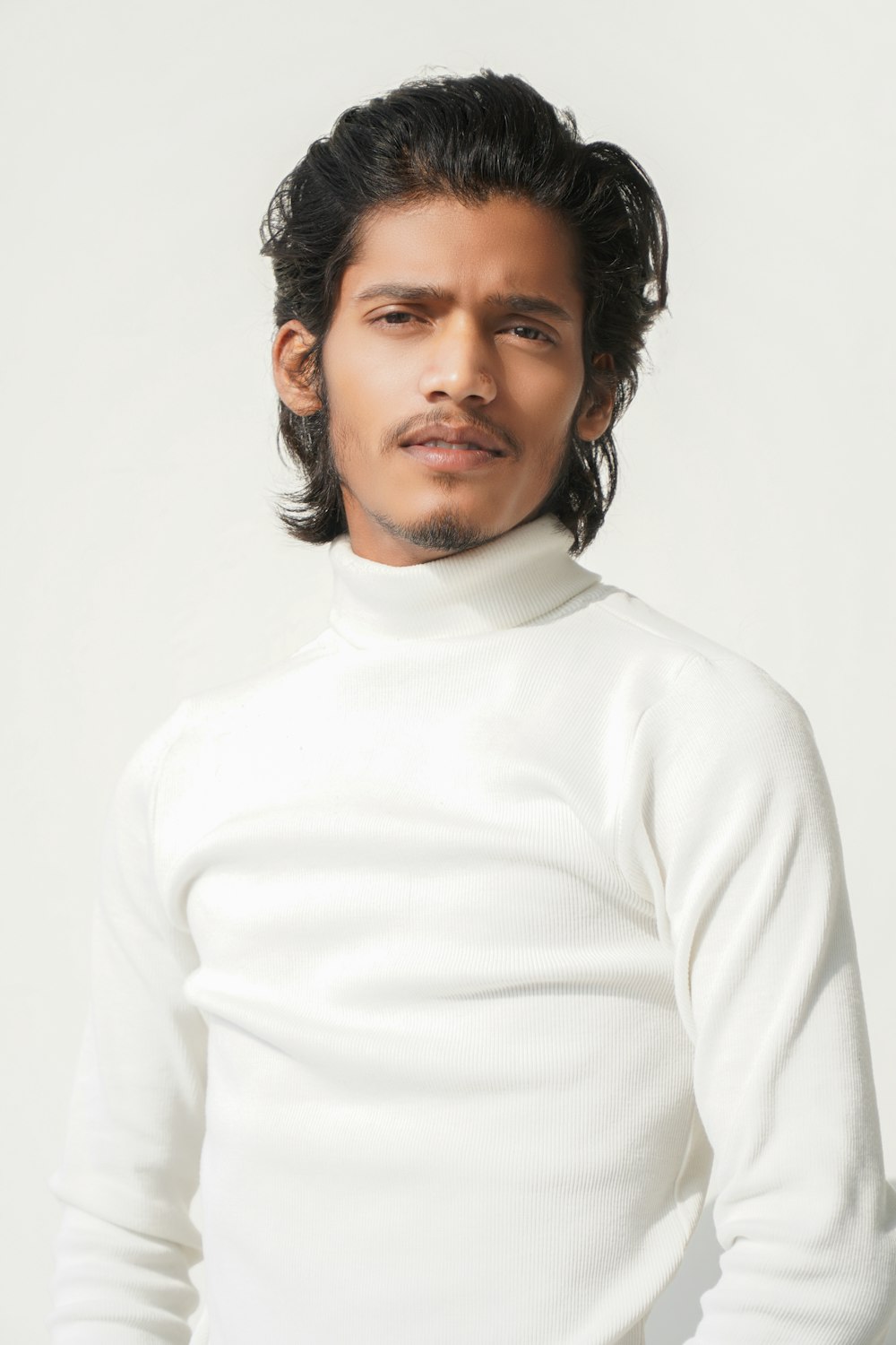 a man in a white turtle neck sweater