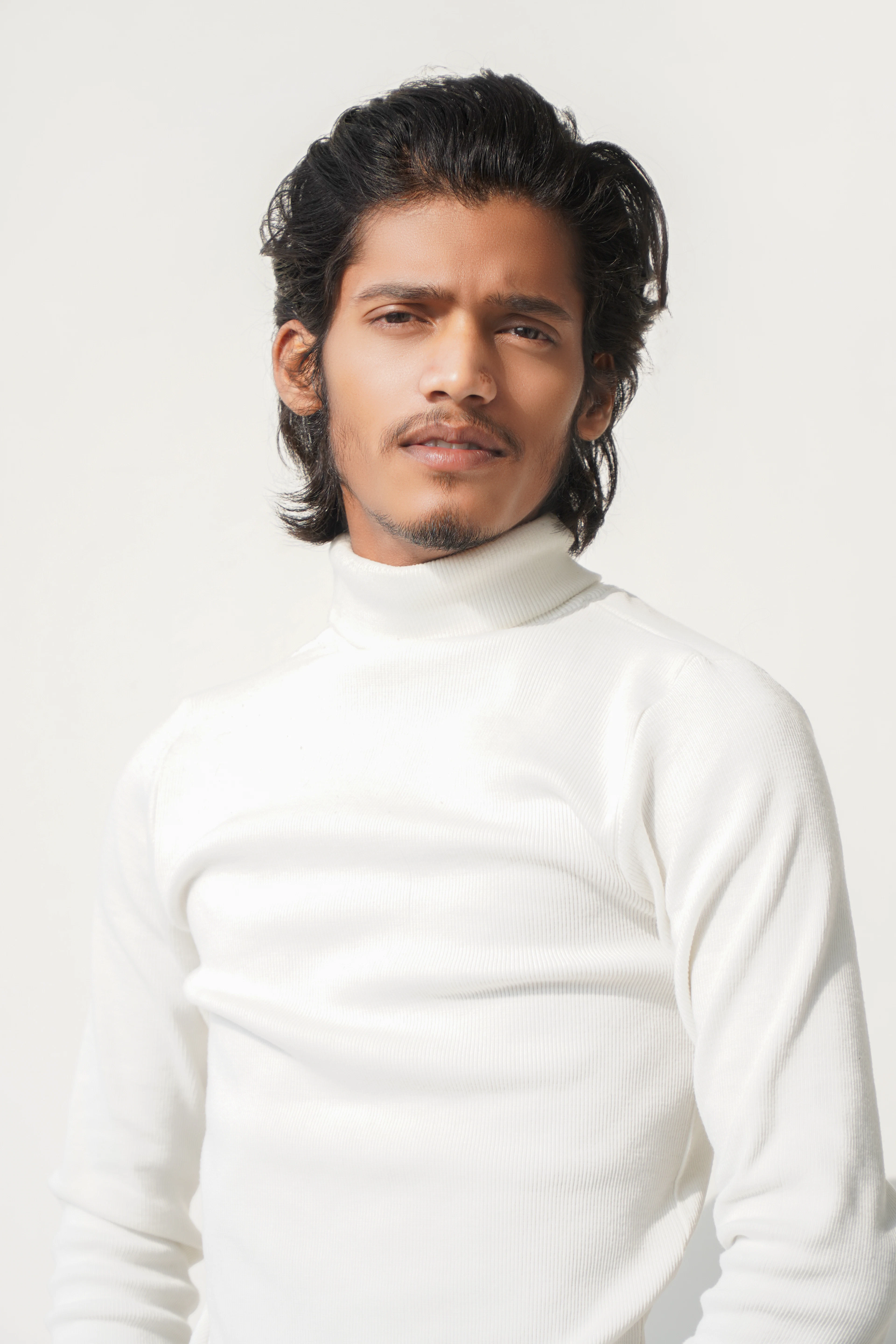 Man wearing an ivory ribbed turtleneck sweater