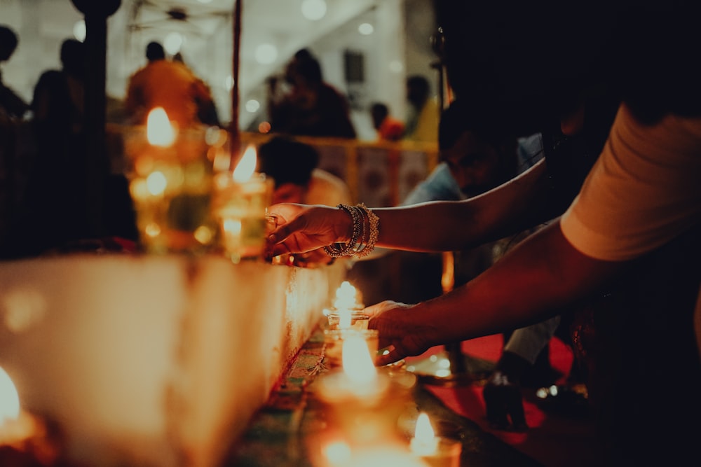 a group of people standing around a table with candles