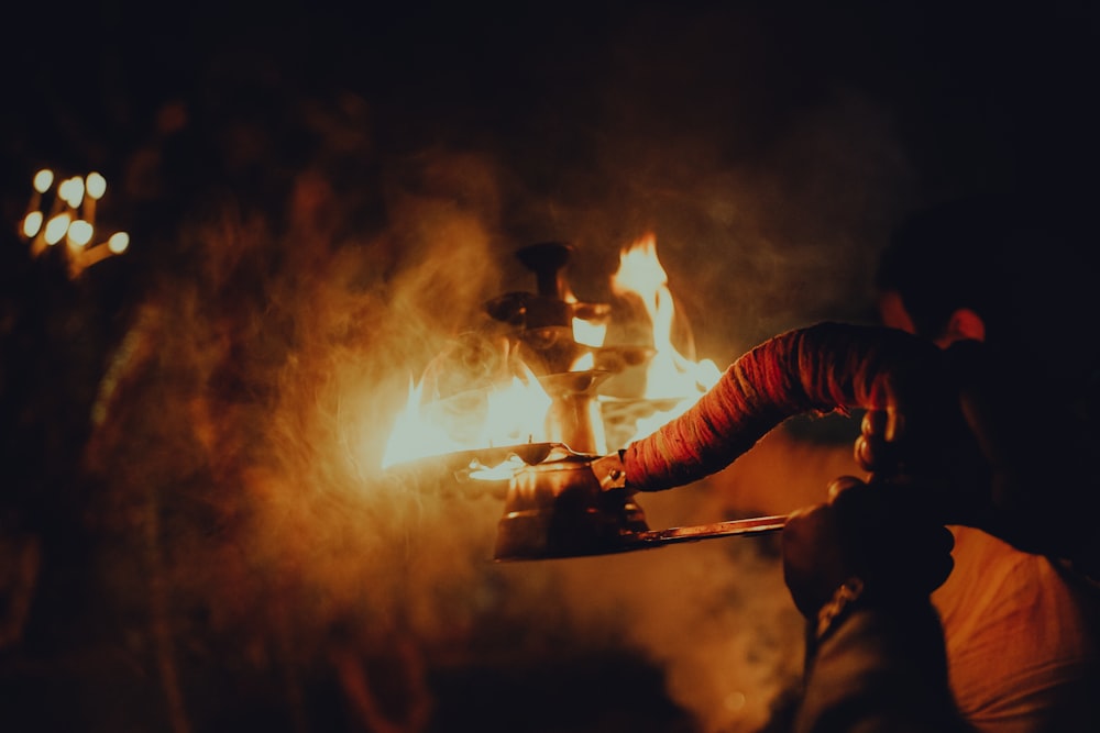 a person holding a lit candle in their hand