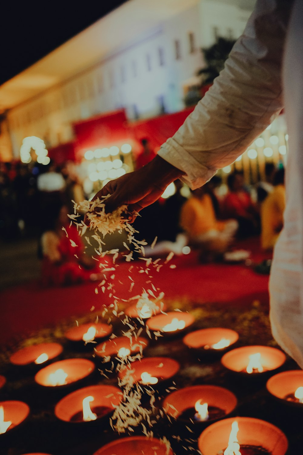 a person standing over a bunch of lit candles