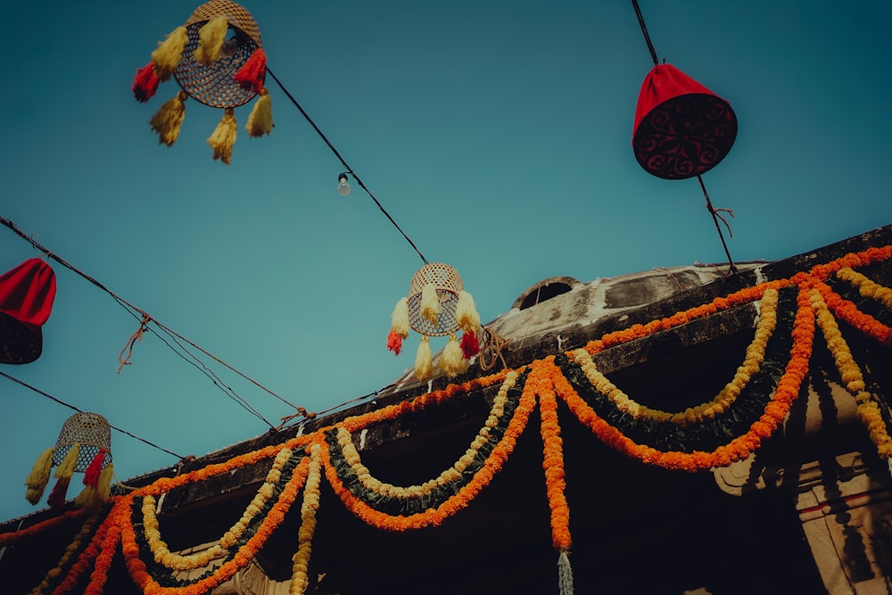 a group of decorations hanging from wires on top of a building