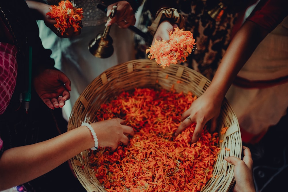 a group of people standing around a basket filled with food