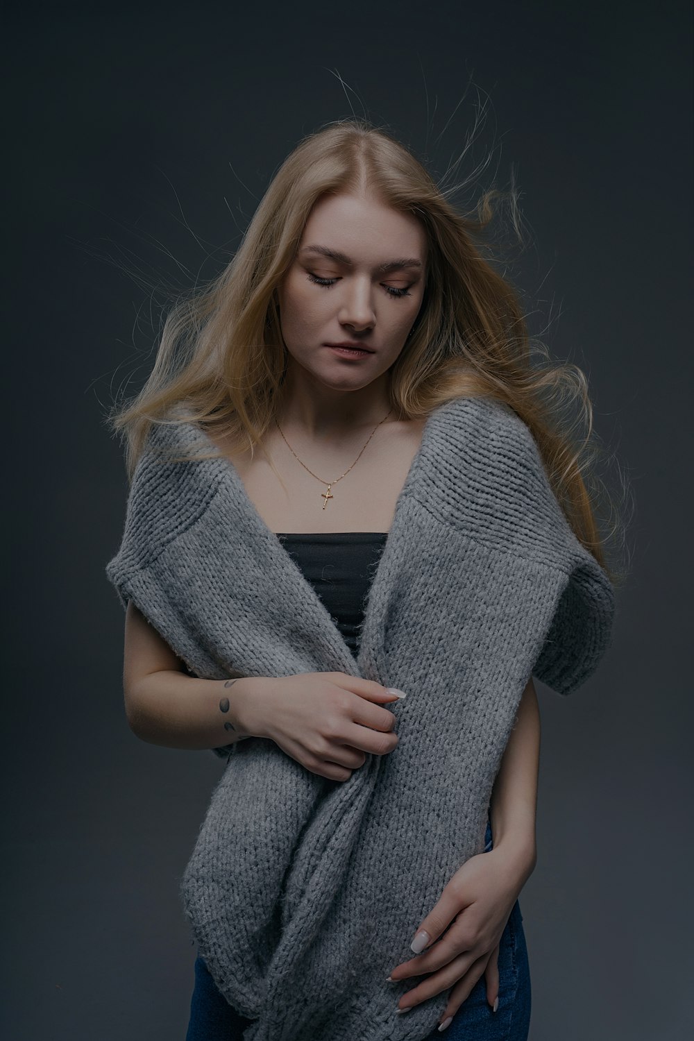 a woman with long hair wearing a gray sweater
