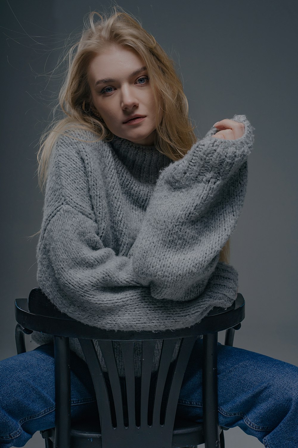 a woman sitting on top of a black chair