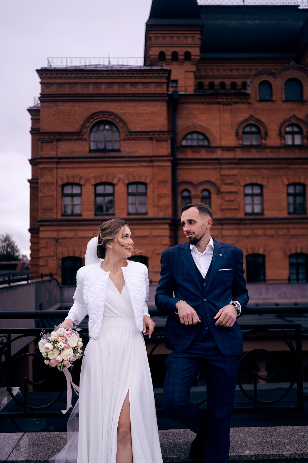 a bride and groom standing in front of a building