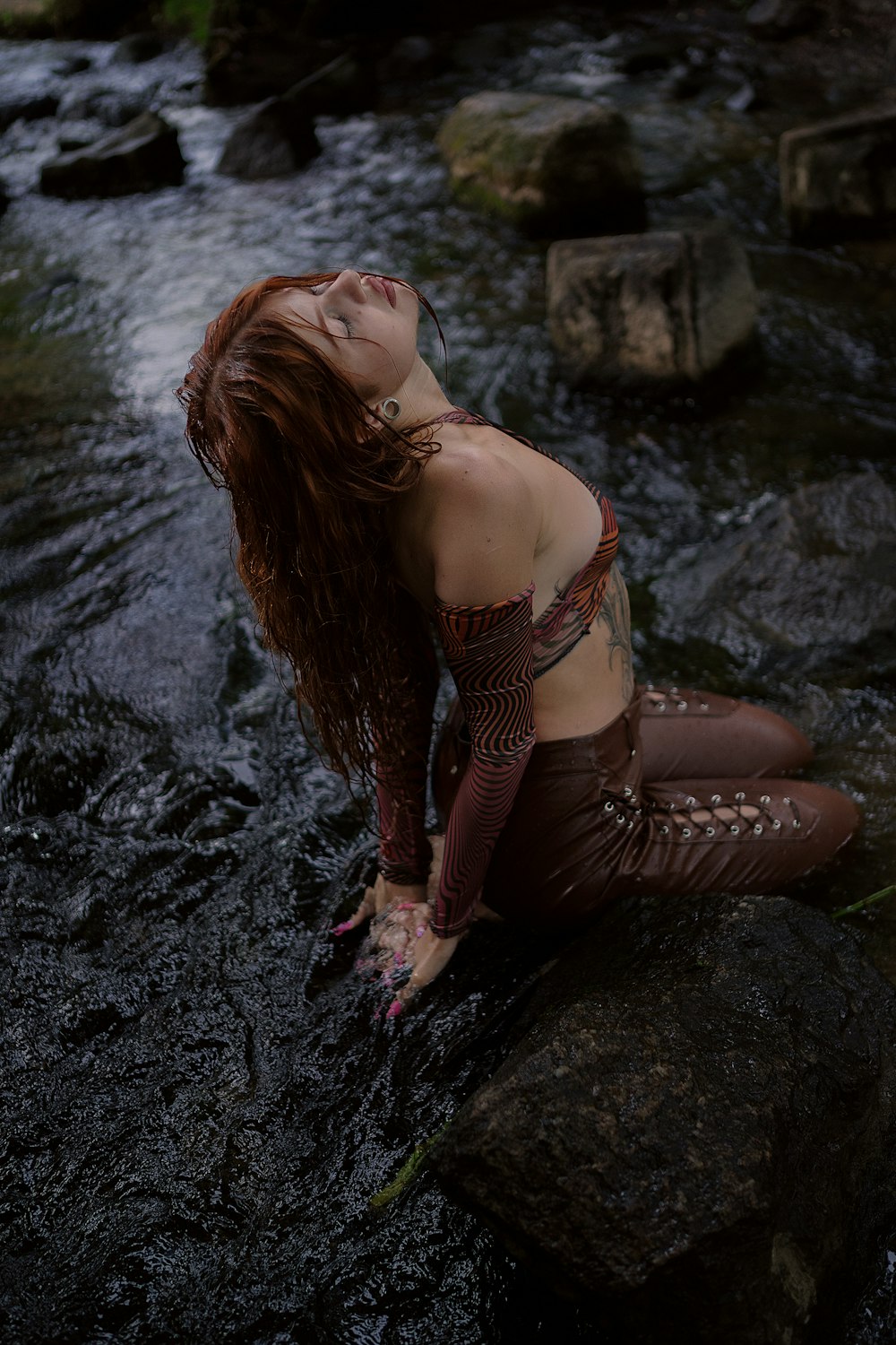 a woman sitting on a rock in a river