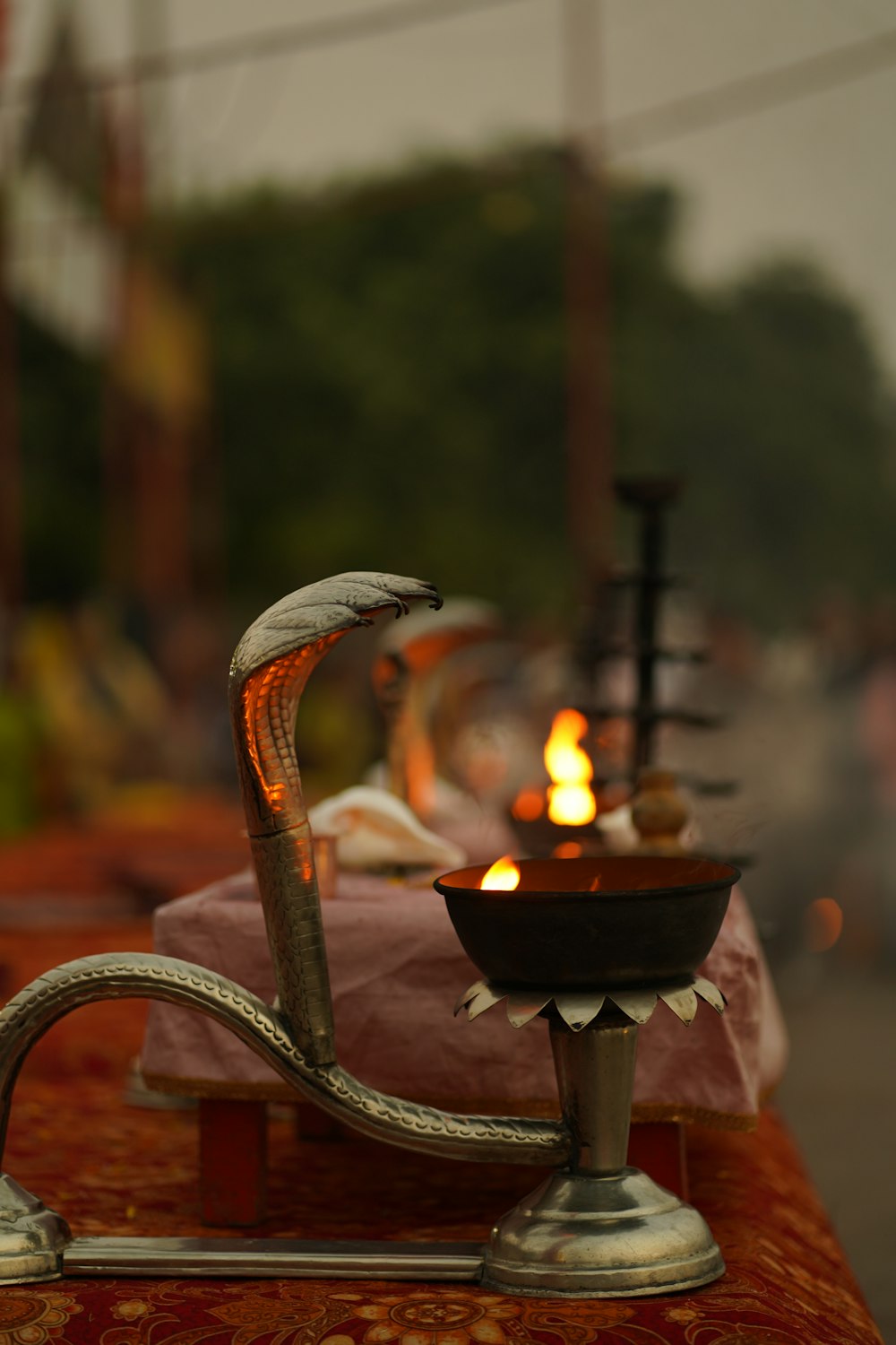 a metal hookah with a lit candle in the middle of it