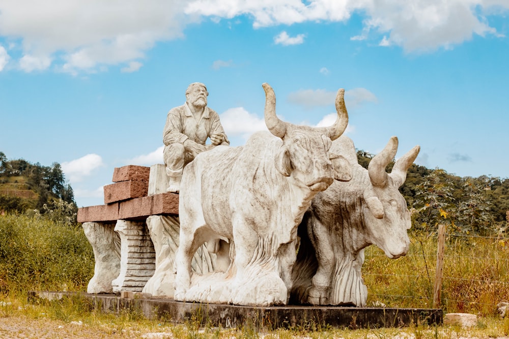 a statue of a man sitting on top of a bull