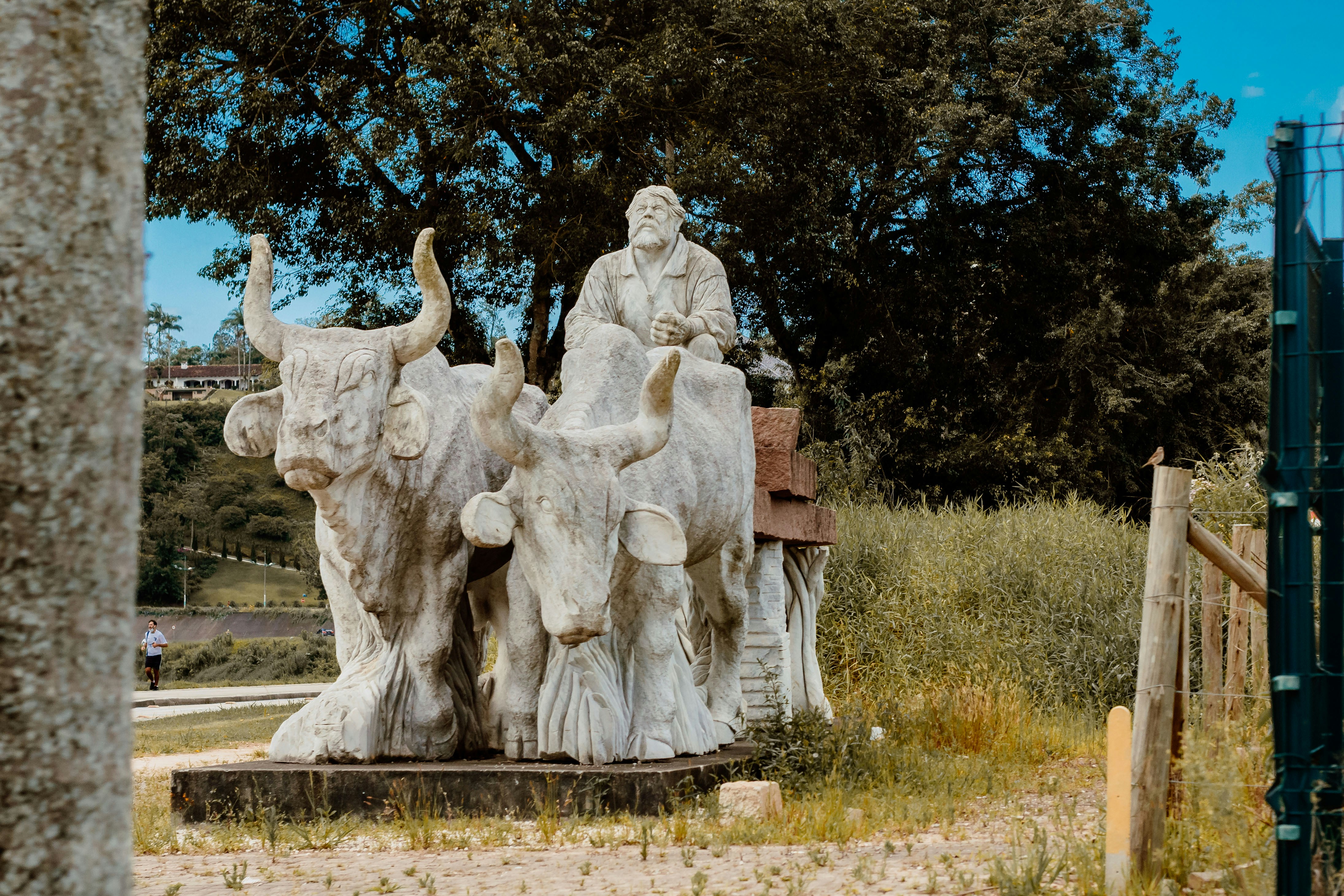 a statue of a man riding a bull with two men on it