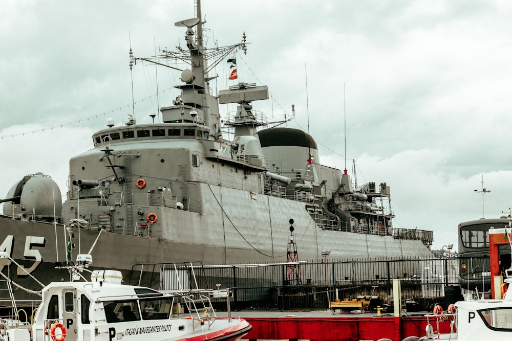 a large gray ship docked at a dock