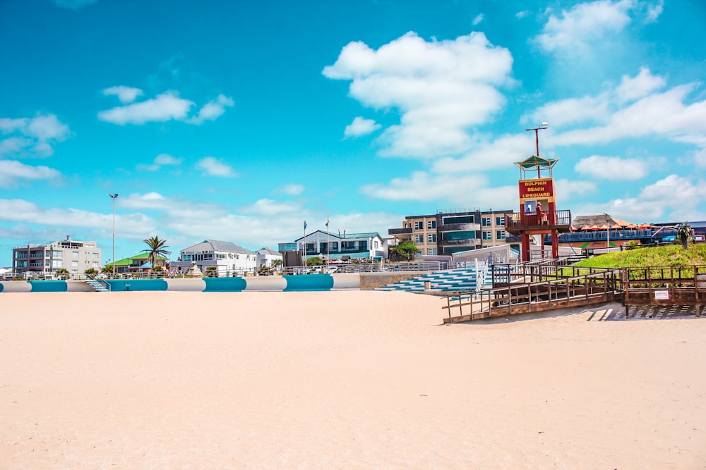 a sandy beach with a few buildings in the background