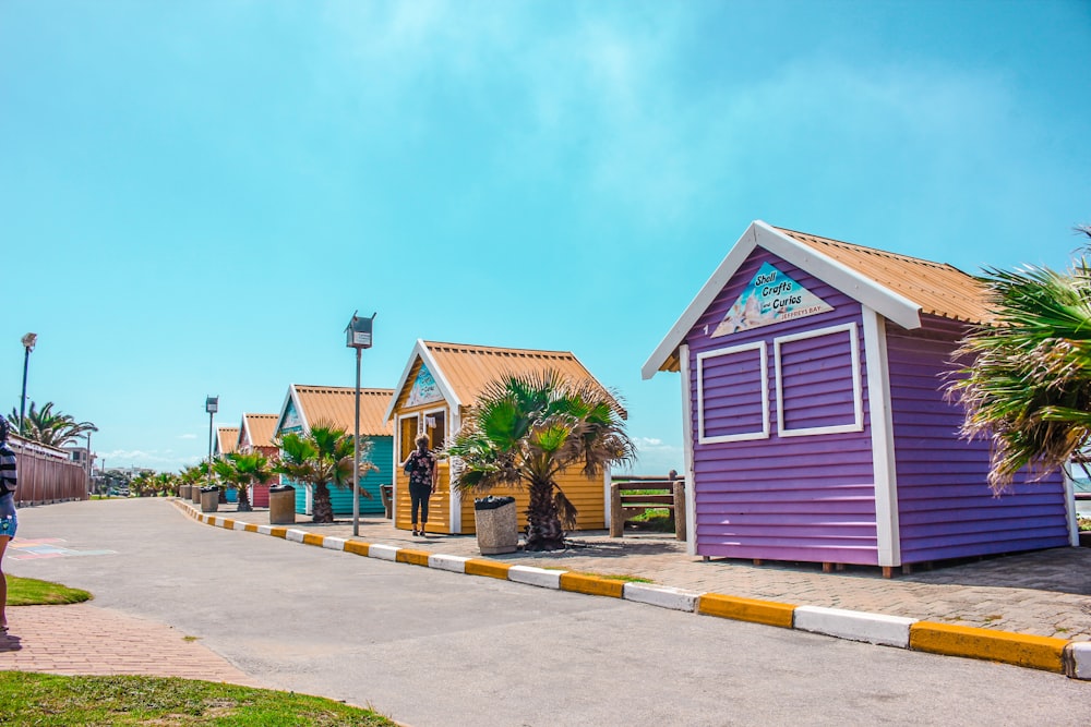 a row of colorful beach huts next to the ocean