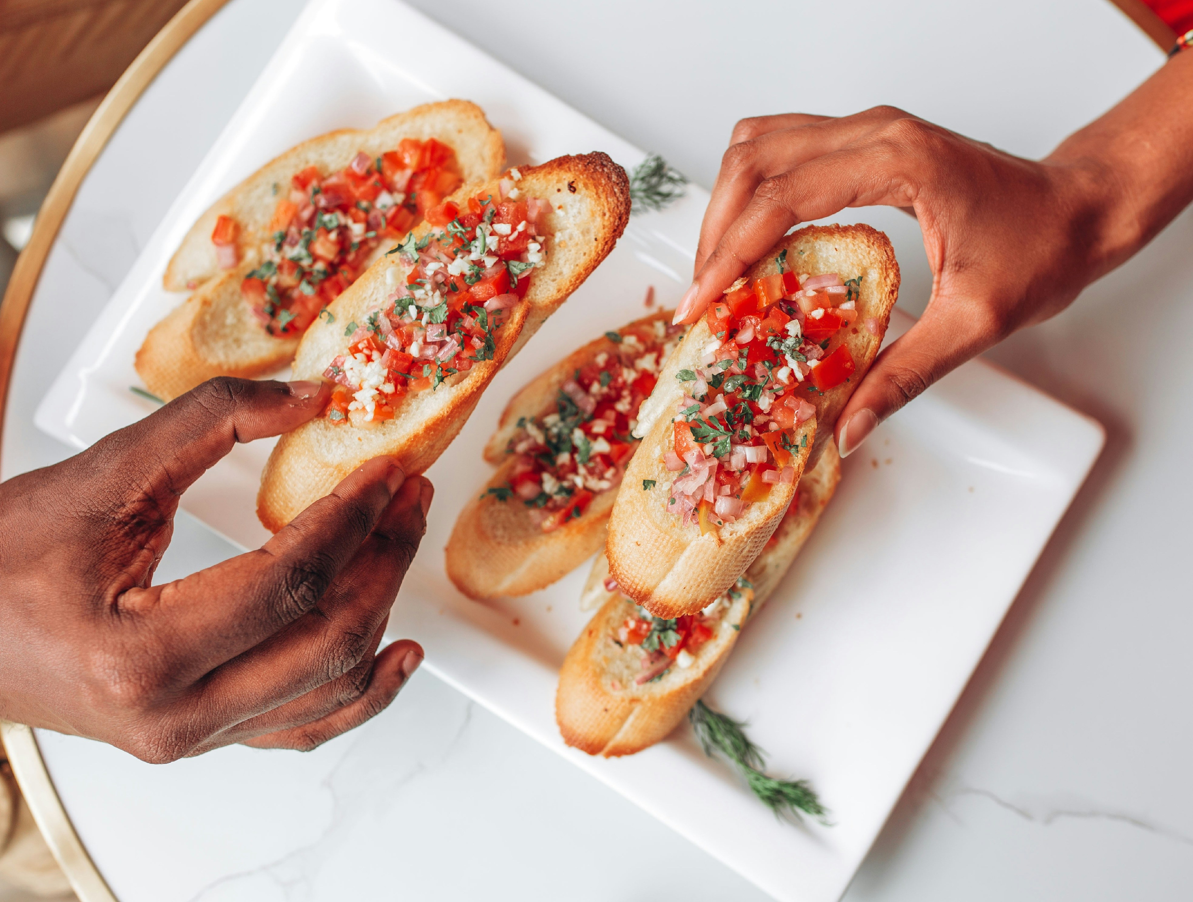 Hand reaching for tomato bruschetta