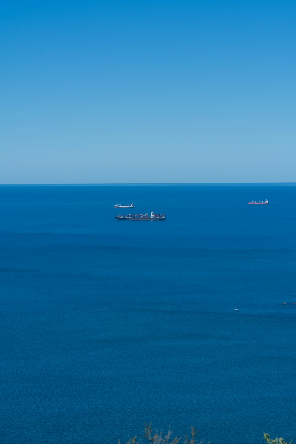a large body of water with two ships in the distance