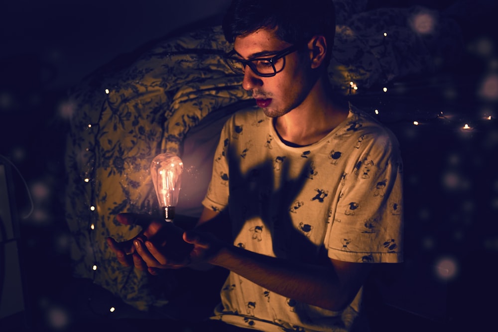 a young man holding a lit candle in his hand