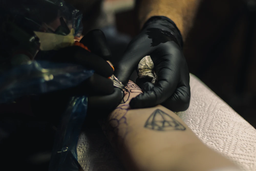 A person receiving a tattoo on the forearm.