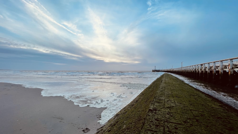 a pier on a beach with a body of water