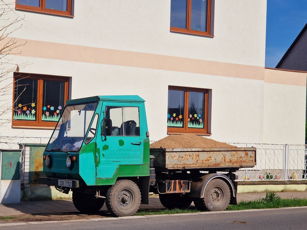 a green truck parked on the side of a road