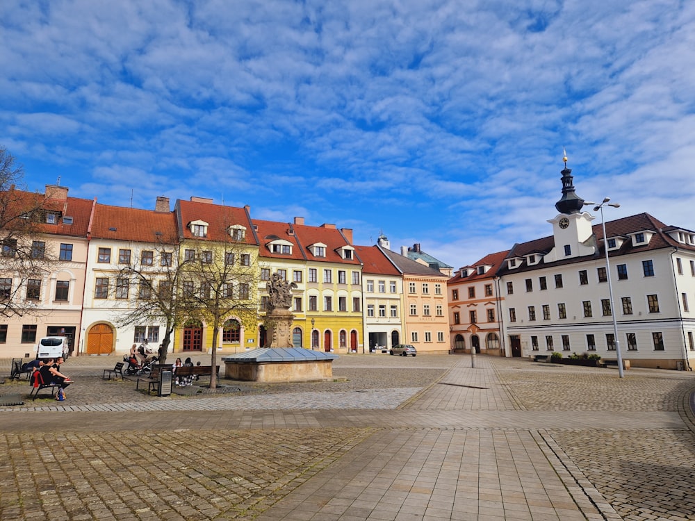 a cobblestone street lined with buildings and a clock tower