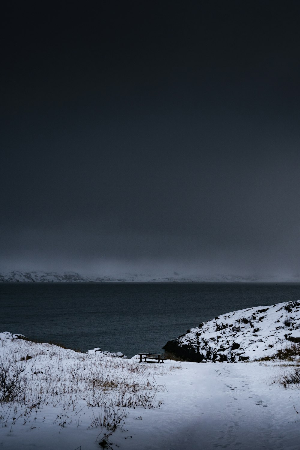 a bench sitting on top of a snow covered field