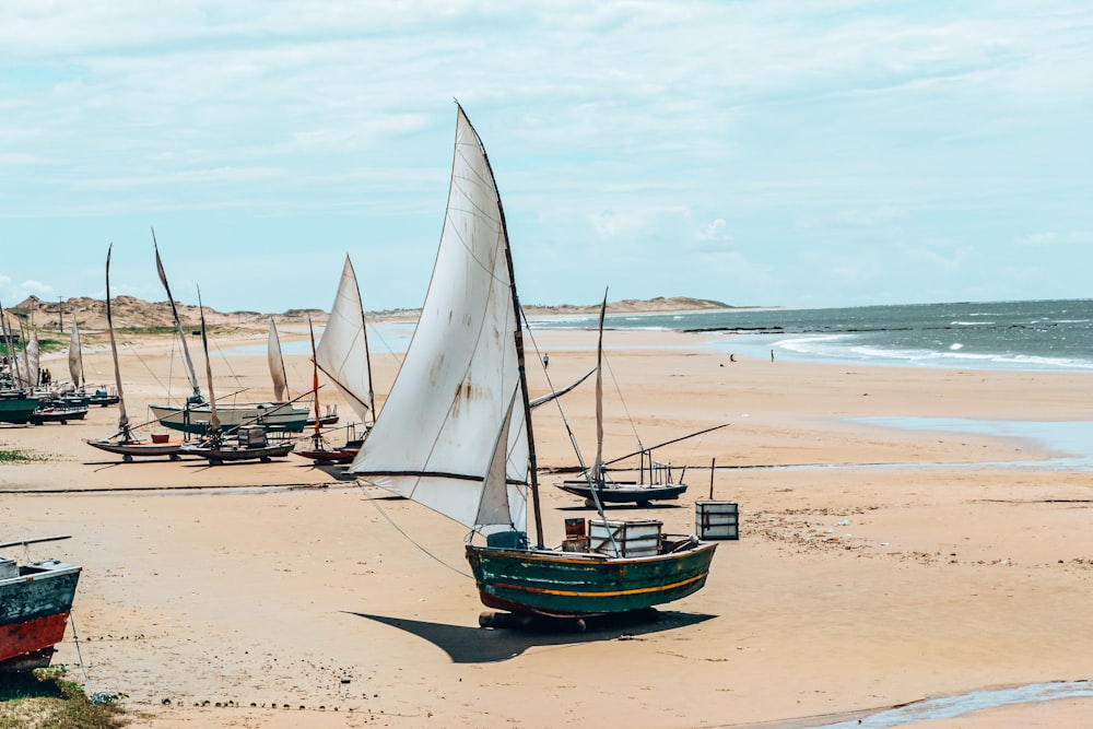 a group of boats sitting on top of a sandy beach