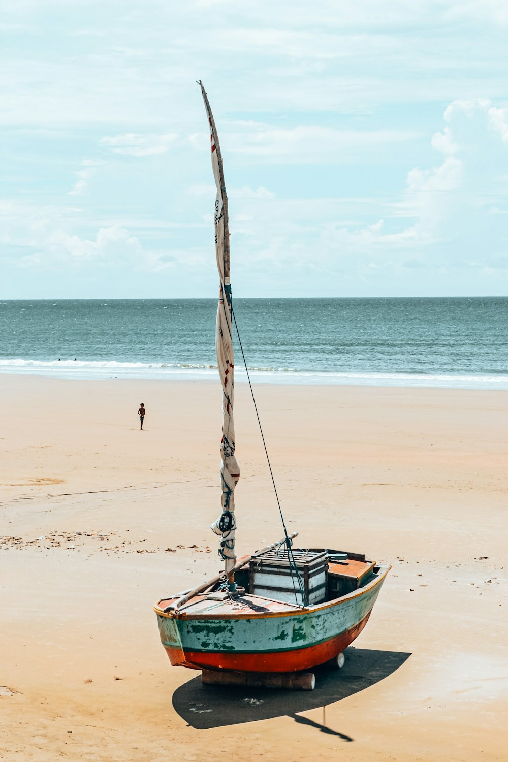 a boat sitting on top of a sandy beach