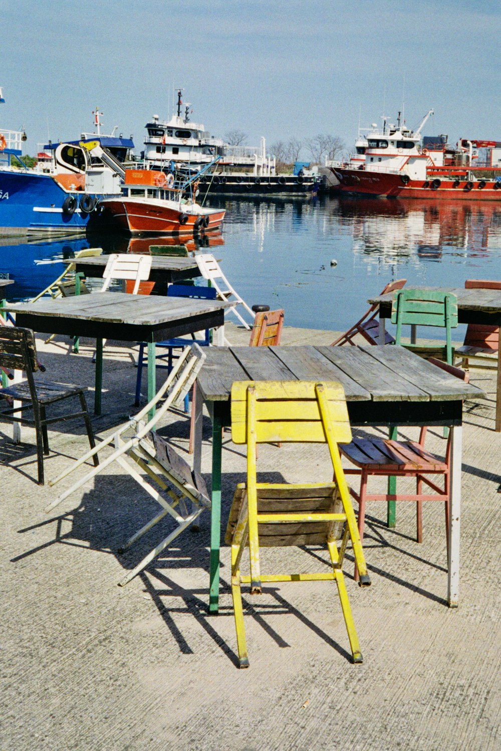 a group of tables and chairs sitting next to a body of water