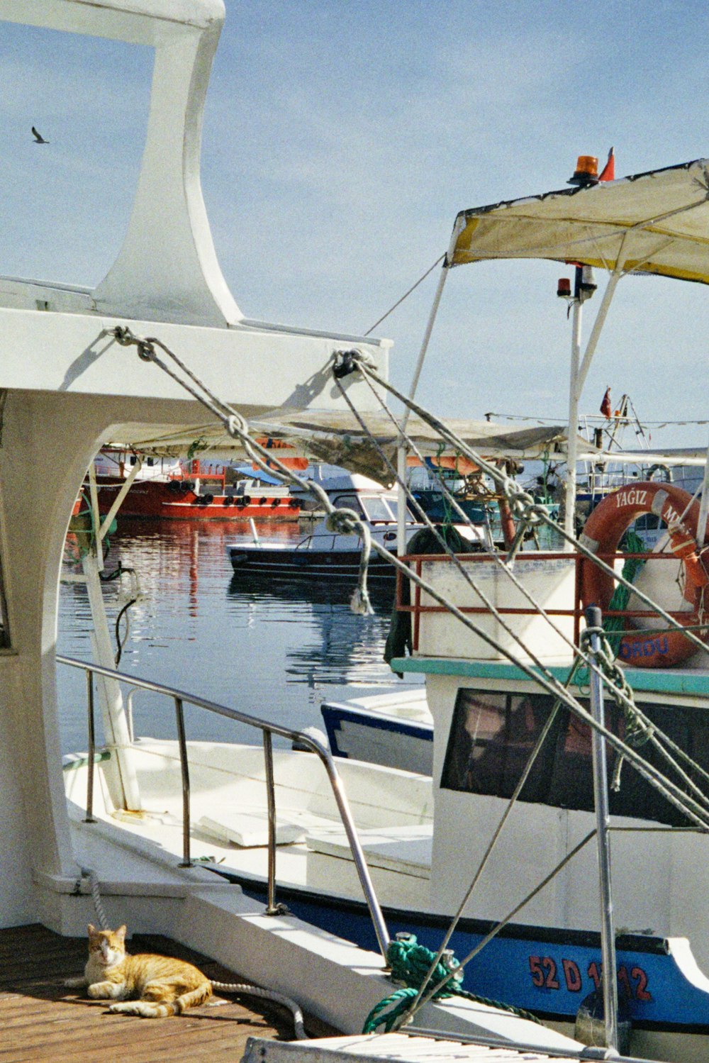 a boat docked at a pier with other boats in the water