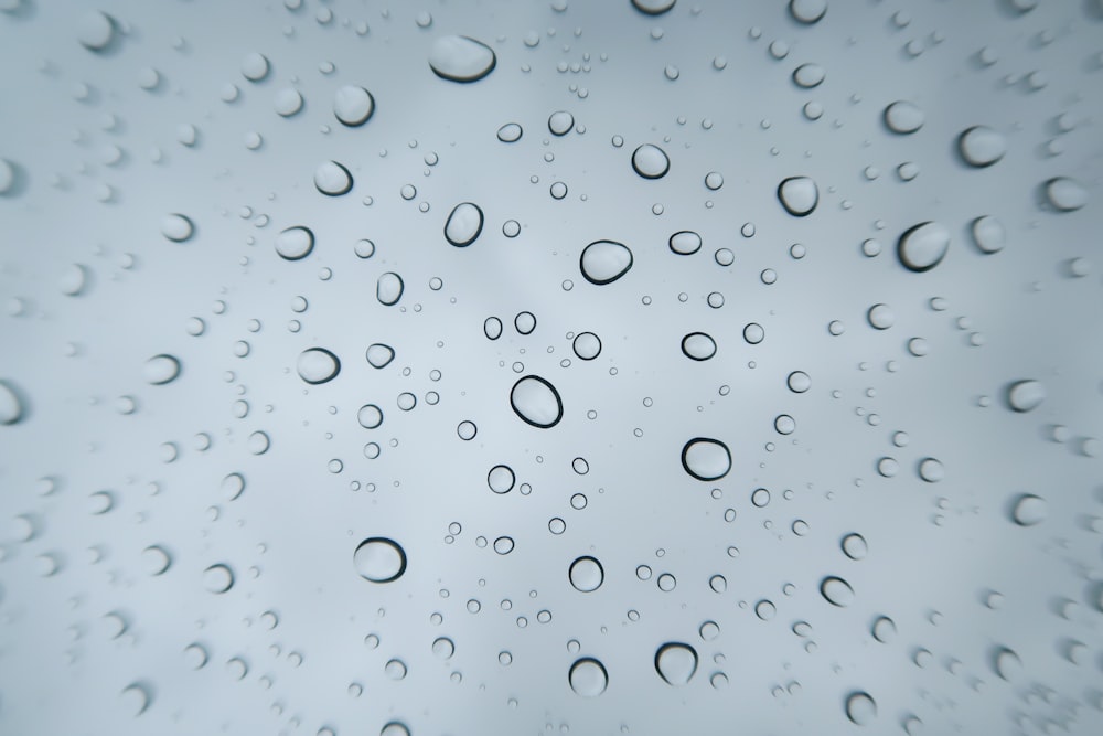 gocce di pioggia su una finestra con un cielo azzurro sullo sfondo