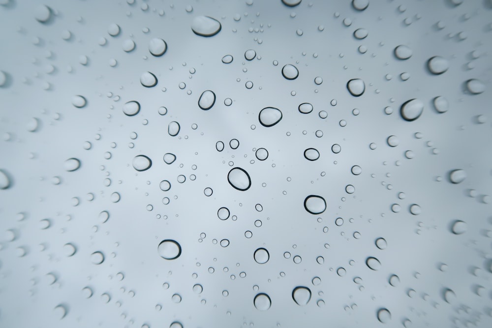 rain drops on a window with a blue sky in the background