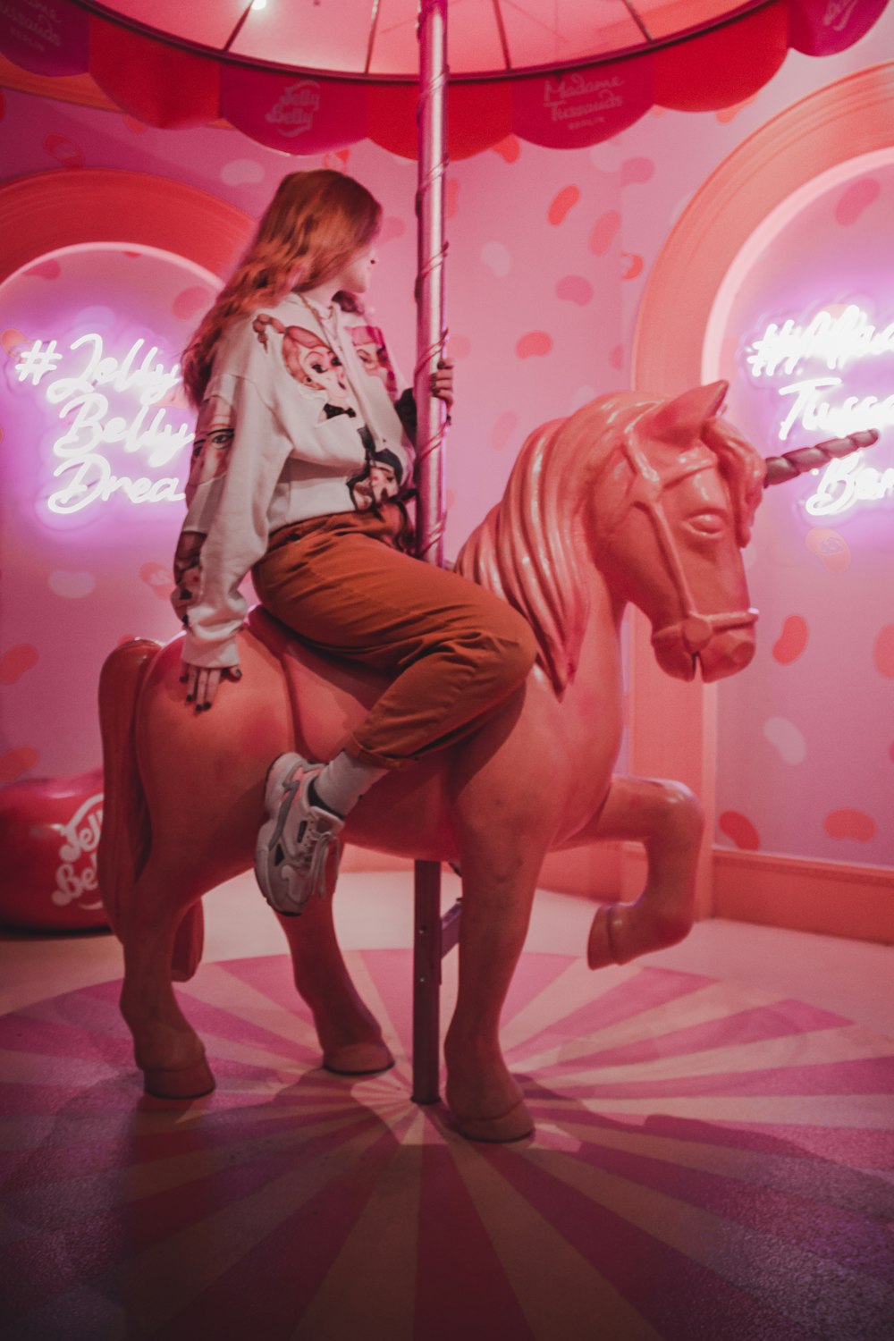 a woman sitting on top of a carousel horse