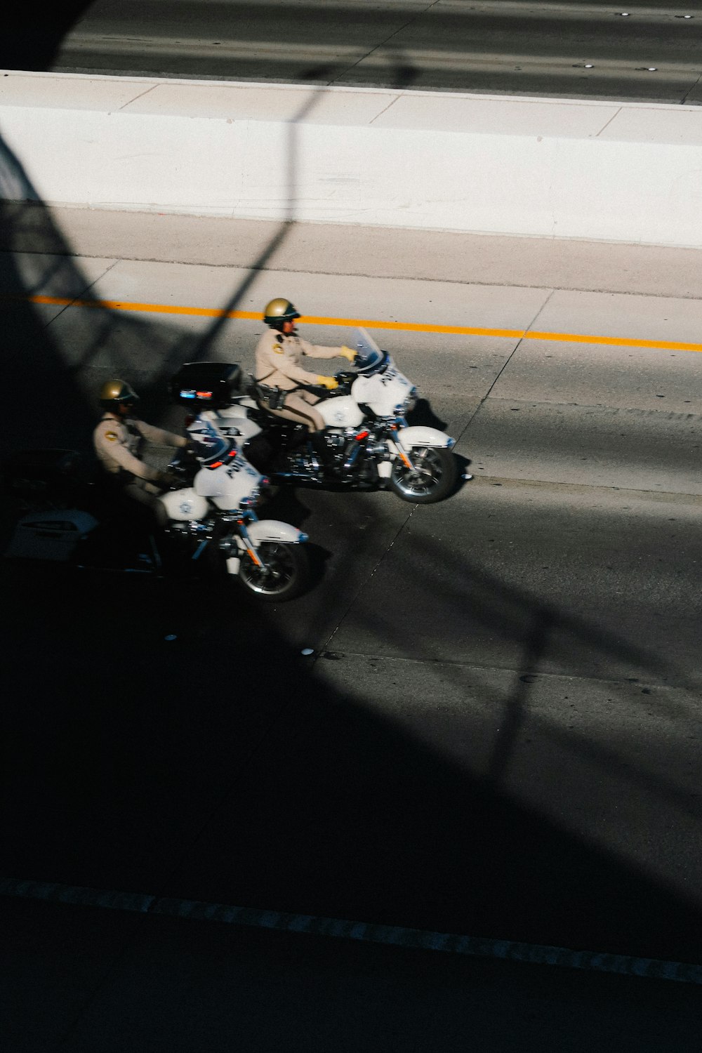 a couple of people riding motorcycles down a street