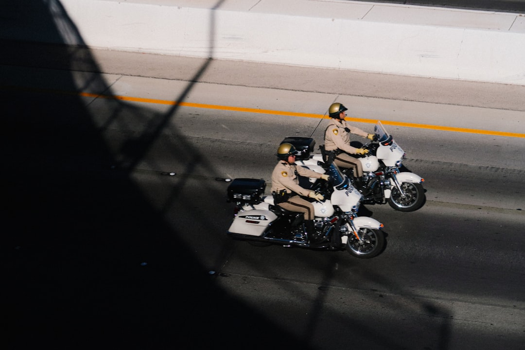 two police officers riding motorcycles down a street,