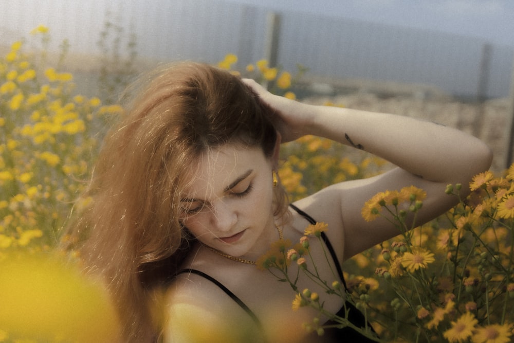 a woman standing in a field of yellow flowers