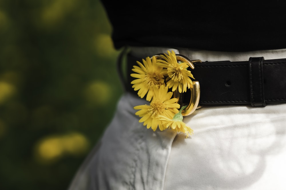 a close up of a person wearing a belt with flowers on it