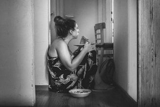 a woman sitting on the floor eating food