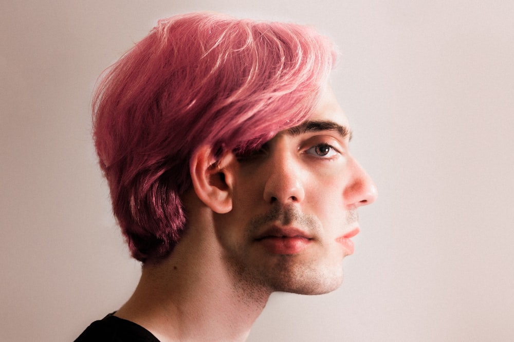 a man with pink hair and a black shirt