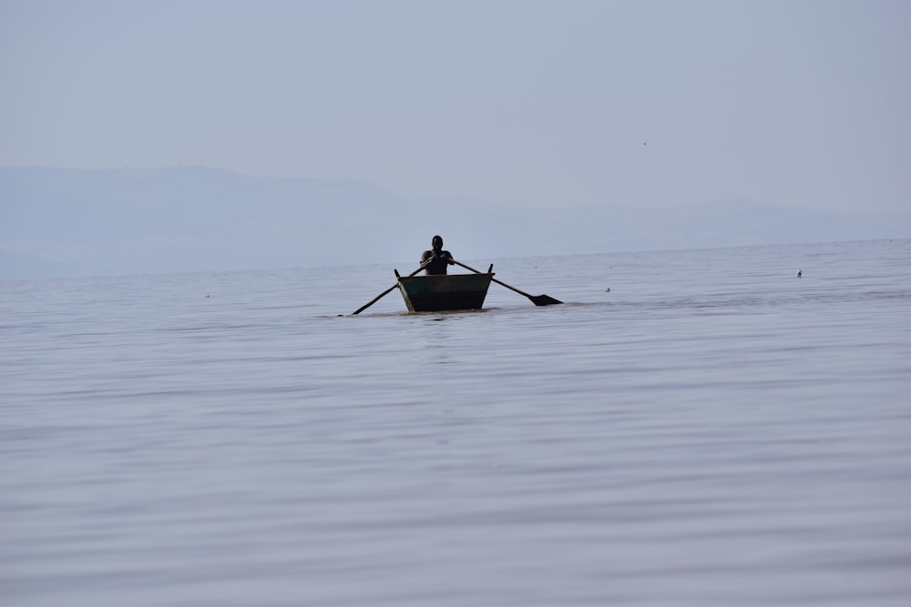 a person in a row boat on the water