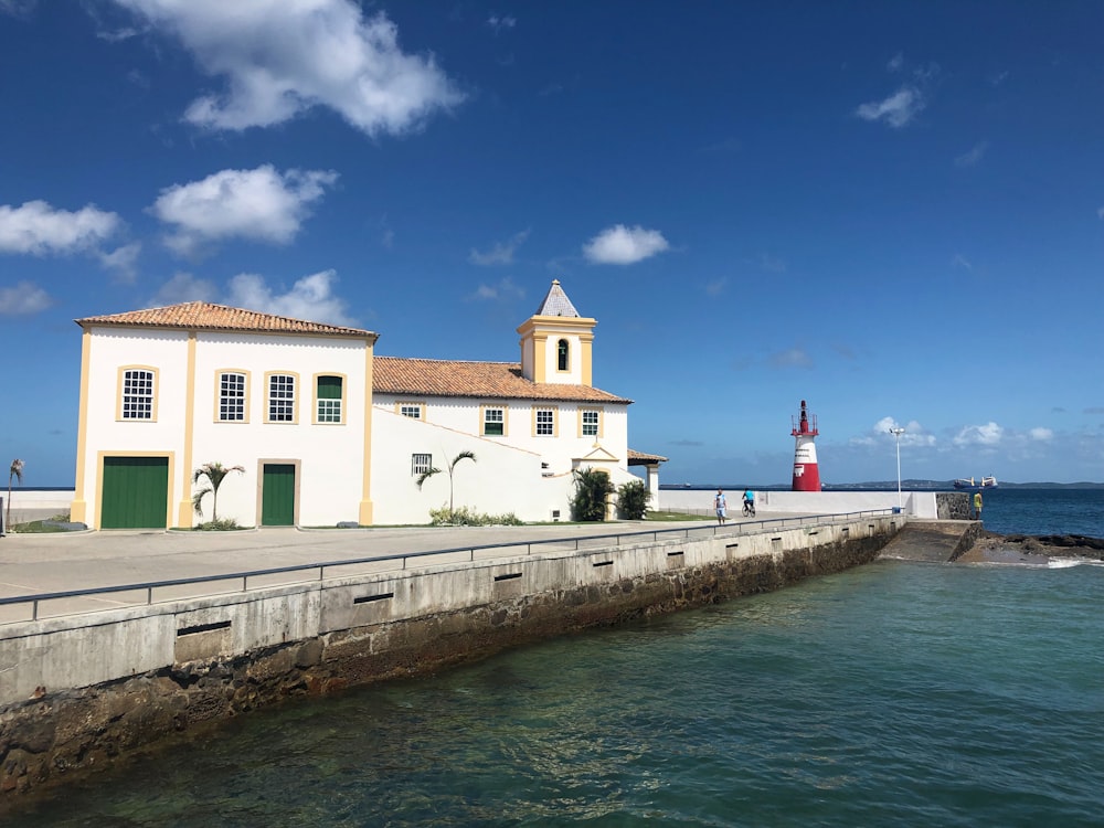 un grand bâtiment blanc assis à côté d’un plan d’eau