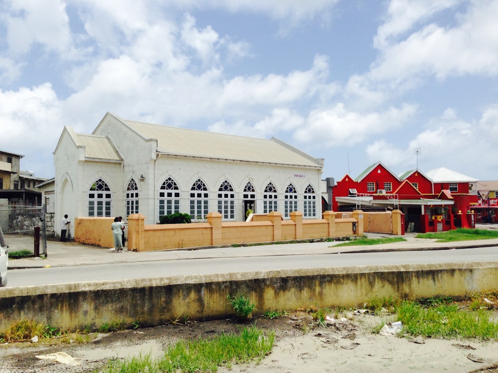 a white church with a red building in the background