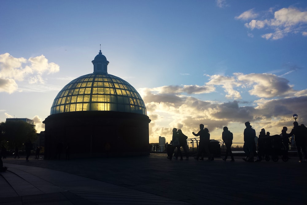 a group of people standing in front of a domed building