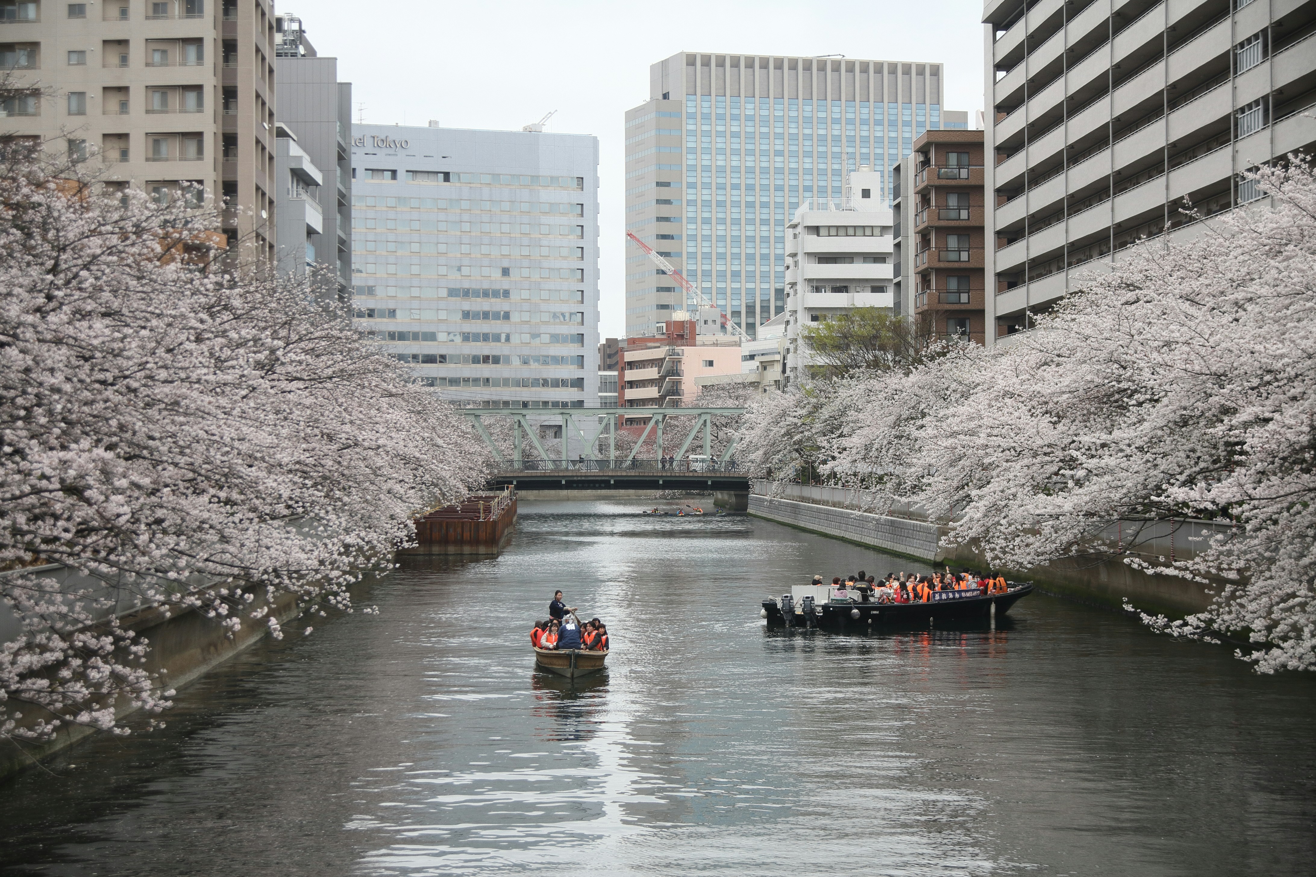 two boats are traveling down a river in a city