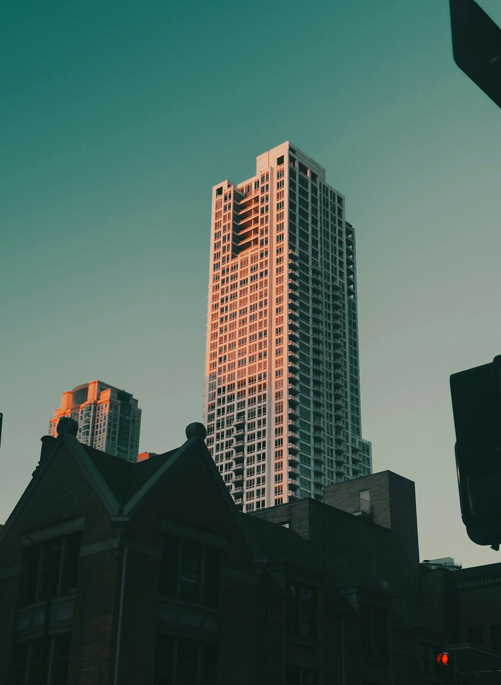 a tall building towering over a city next to a traffic light