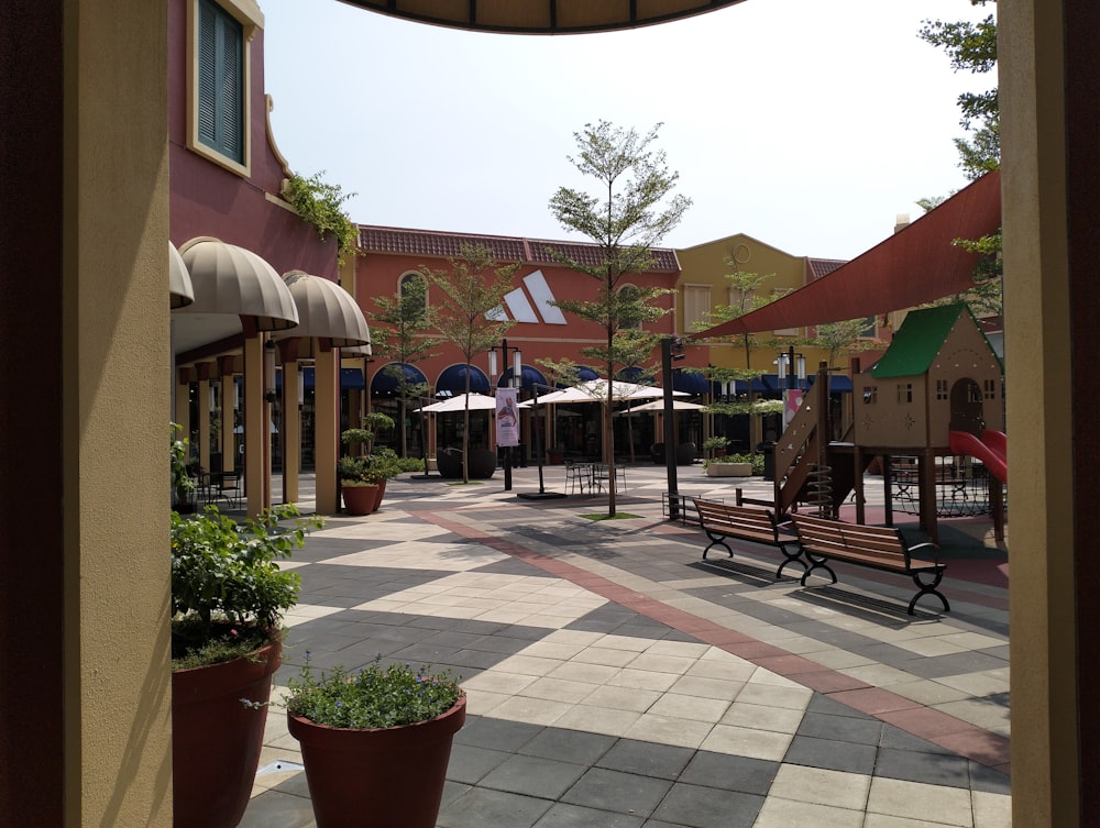 a view of a courtyard with a playground in the background