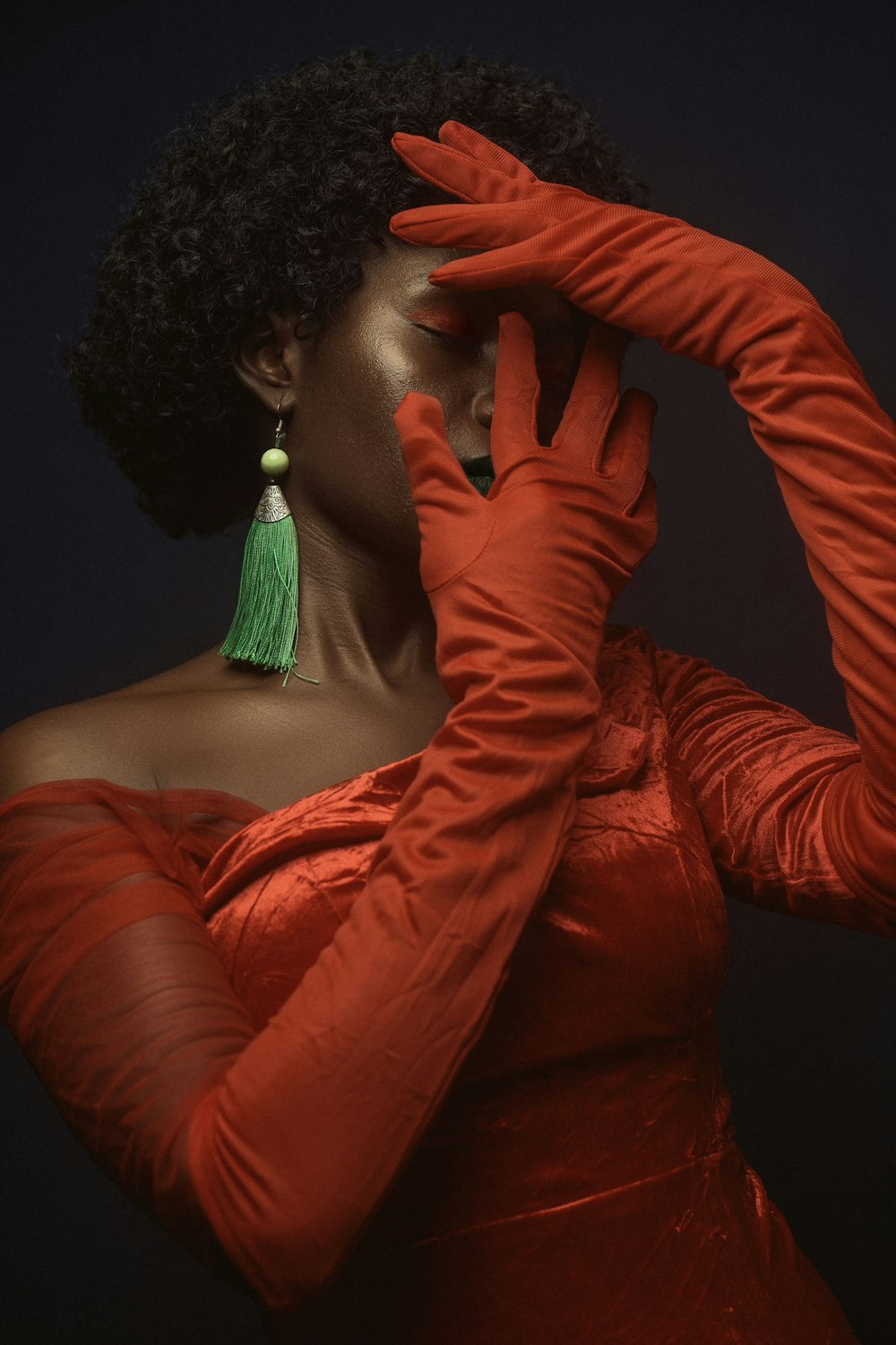 una donna in un vestito rosso con una nappa verde