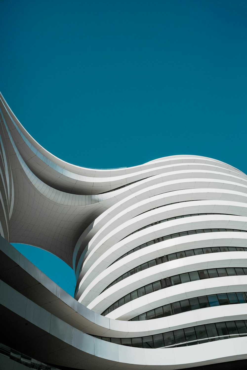 a tall building with a curved roof against a blue sky