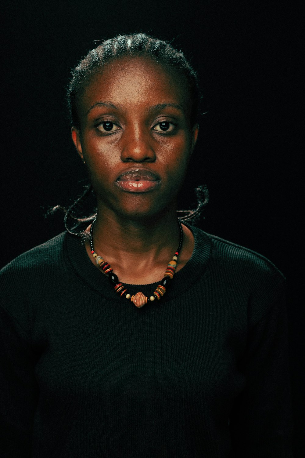 une femme en chemise noire et collier